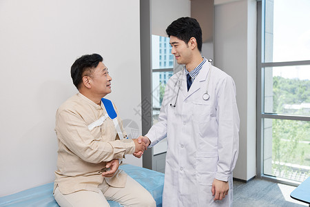 医生与骨折患者交谈握手图片