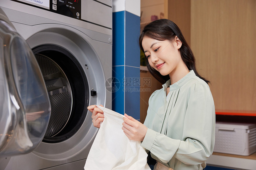用酒店洗衣机洗衣服的女白领图片