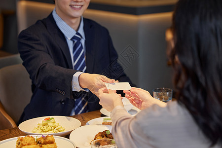 酒店餐厅生意合作伙伴递名片特写背景图片