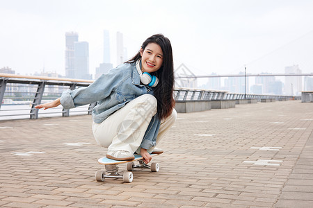 街头时尚青年美女玩滑板图片