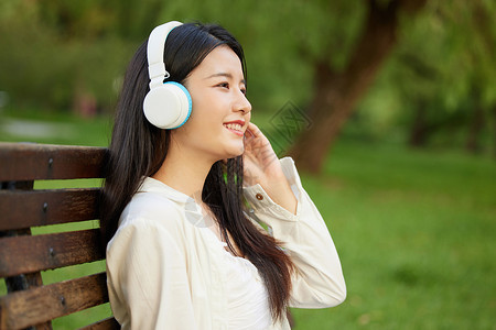 户外戴耳机的年轻女性背景图片