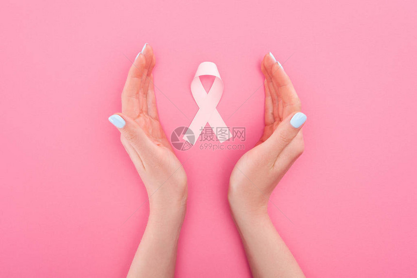 女生双手圈着一个代表抗击乳腺癌的粉红丝带图片