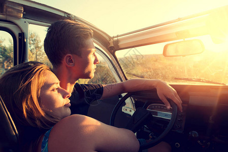 快乐的一对年轻夫妇在一辆汽车享受着美丽的图片