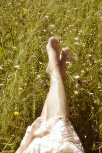 女人躺在温暖的草地上图片