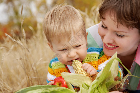 孩子吃玉米她妈笑了。图片