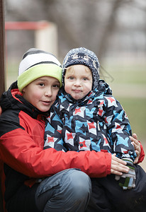 两个可爱的小兄弟在户外地包裹着寒冷的天气图片