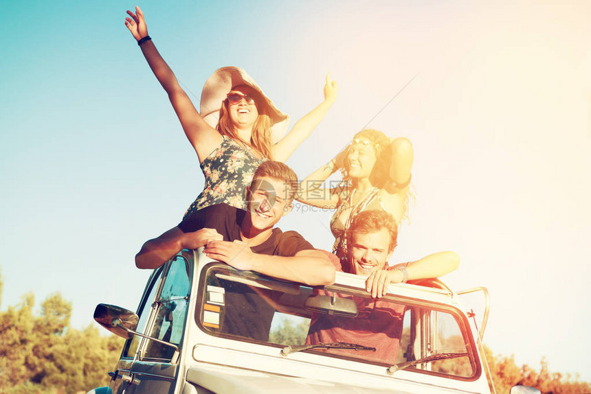 一群欢乐的人们在夏天日落时开着汽车图片