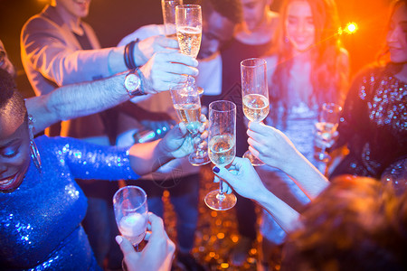 多民族群体笑的年轻人在夜总会享受舞蹈派对和喝香槟时图片