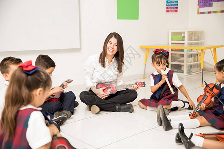 对一群学龄前学生进行音乐教学的有吸引力的西班牙图片