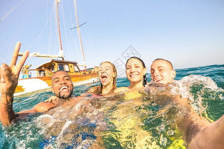 贵宾伊比沙岛年轻的多种族朋友在帆船海上旅行中自拍和游泳富有的快乐男孩和女孩在夏日聚会日玩得开心独家度假概念明亮的午背景