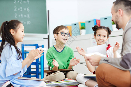 小学生在上课的同时向教师鼓掌赞美图片