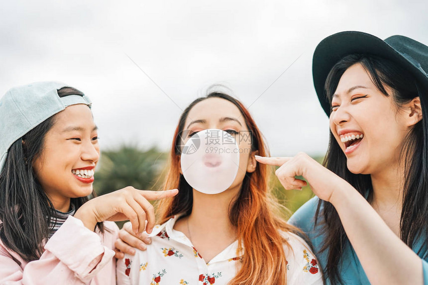 快乐的亚洲朋友在户外嚼泡糖玩得开心年轻人一起玩耍和大笑友谊千禧一代和青年图片