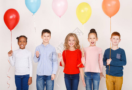 一群带着彩色气球在白墙上的孩子图片