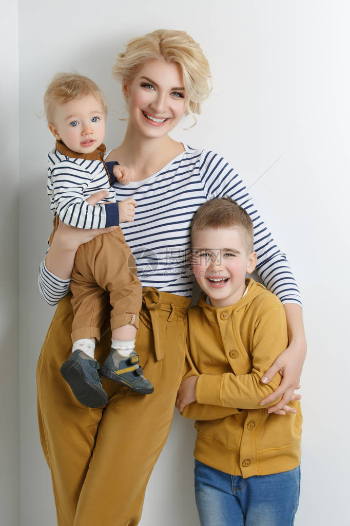 美丽的年轻女子和两个小男孩母亲和儿子穿着条纹的散装图片