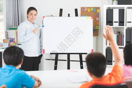 年轻的亚洲教师在课堂上用Blabk白人板质问年图片
