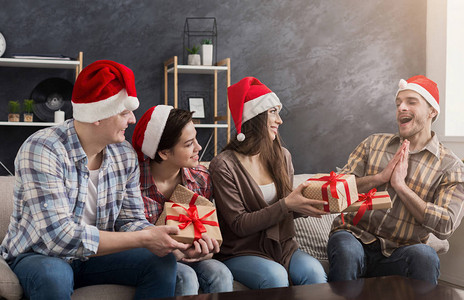 一群快乐的朋友在家里欢笑和分享圣诞礼物图片