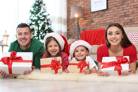 在家圣诞附近带礼物的快乐父母和子女背景图片
