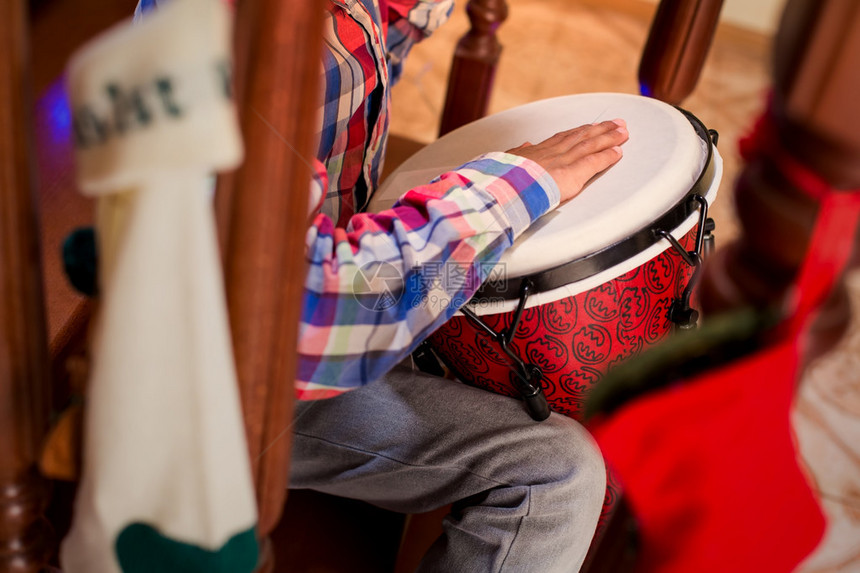 Mulatto儿童打敲鼓男孩在楼梯上玩djembe在家里演奏圣诞音乐图片