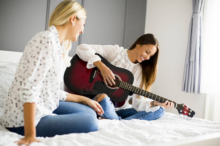 两个在家床上弹吉他图片