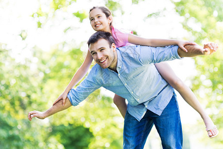 快乐的父亲和女儿在公园玩得开心图片