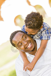 快乐的非洲裔美国父亲和混合种族男孩在公图片