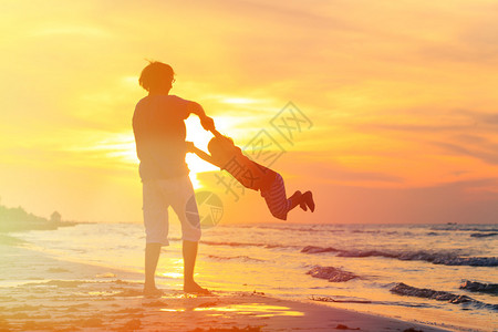 父亲和小儿子剪影在日落玩耍图片