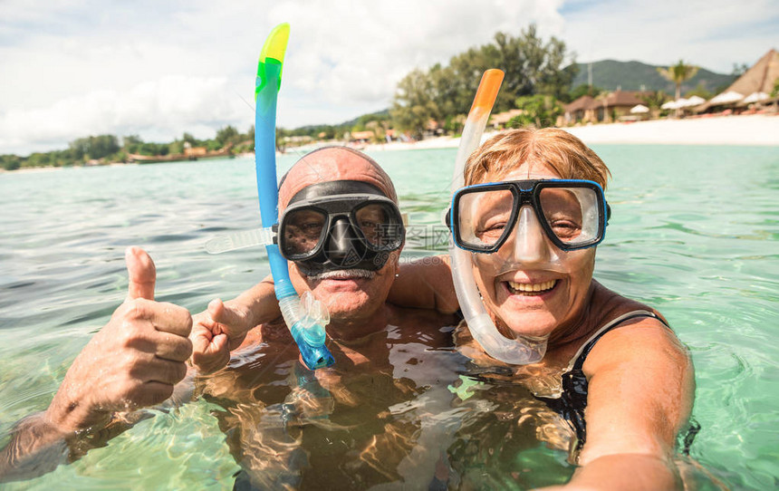 年长的幸福夫妇在热带海上游览中用水上相机自拍在异国情调的场景中乘船浮潜活跃的退休老人和世界各地的有趣概念温暖图片