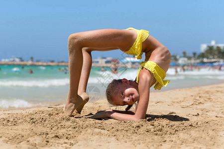 在沙滩上做瑜伽练习的女孩图片