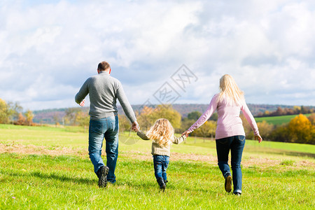 秋天或秋天的家庭步行穿过公园图片