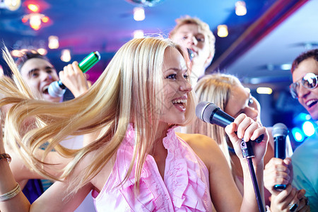 欢乐女孩在派对上歌唱的肖像在快乐朋友图片
