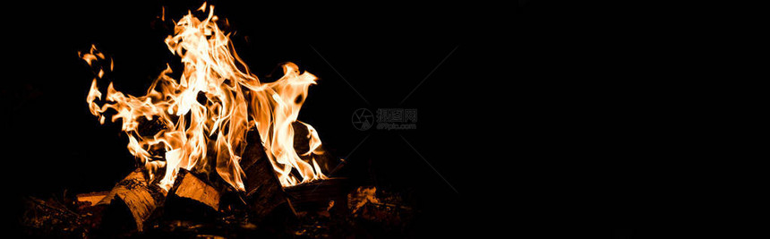 黑暗中在营火中燃烧的原木全景拍摄图片