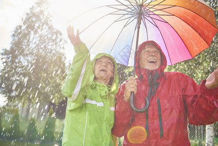 老夫妇撑伞玩雨图片