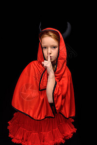 儿童穿着神圣的魔鬼装扮戴着隐密标志在图片