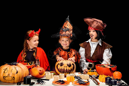 孩子们穿着神圣的恶魔巫婆和海盗服装带着杰克奥灯笼和糖果在图片