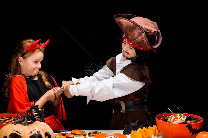 孩子们穿着神圣的恶魔和海盗装扮带着神圣的装饰品和糖果在图片