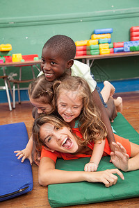 老师和她的学生在地板上玩耍图片