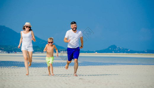 三个快乐的年轻家庭在沙漠阳光明媚的沙图片