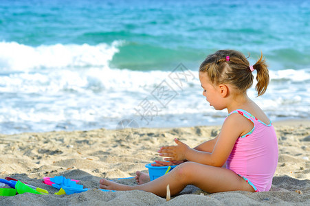 在海滩玩具时微笑的小孩图片