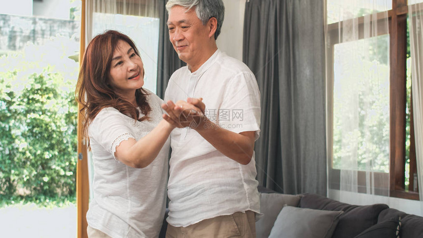 亚洲老年夫妇在家里客厅听音乐时一起跳舞图片