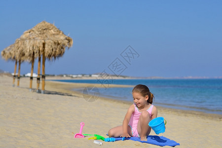 可爱的小女孩用着沙滩玩具玩沙子图片
