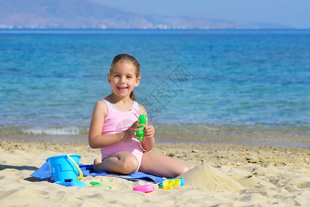 可爱的小女孩用着沙滩玩具玩沙子图片
