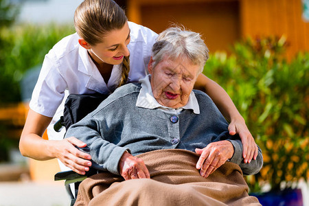 养老院的年长妇女花园护士坐轮图片