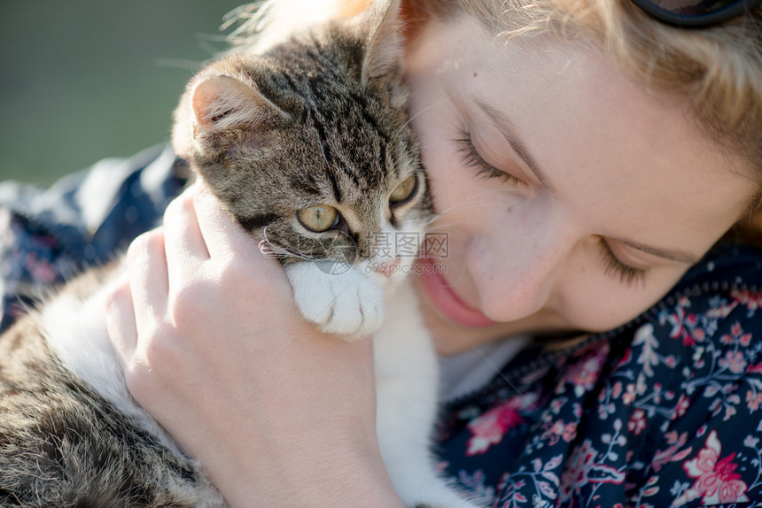 金发女人和可爱的猫咪玩耍图片