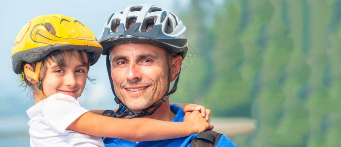 父亲和女儿带着脚踏车头盔快乐地享受图片