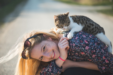 猫咪趴在女生的背上图片