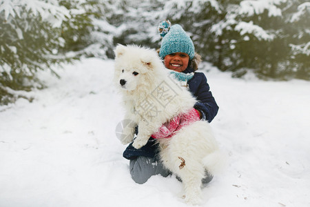 快乐的女孩带着宠物在雪图片