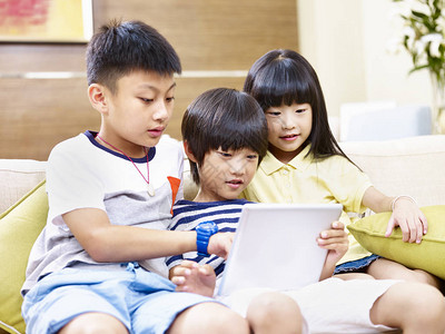 3名亚洲小女孩和小男孩坐在沙发上图片