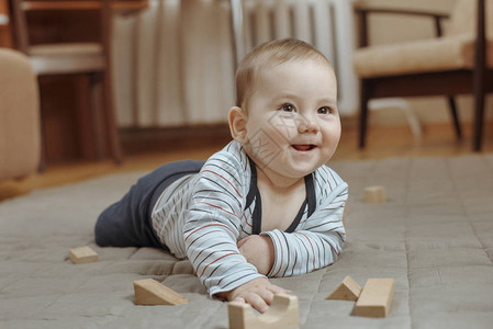 可爱快乐的小男孩在家里的地毯上玩耍图片
