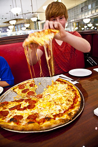 男孩晚上在食客里吃披萨图片