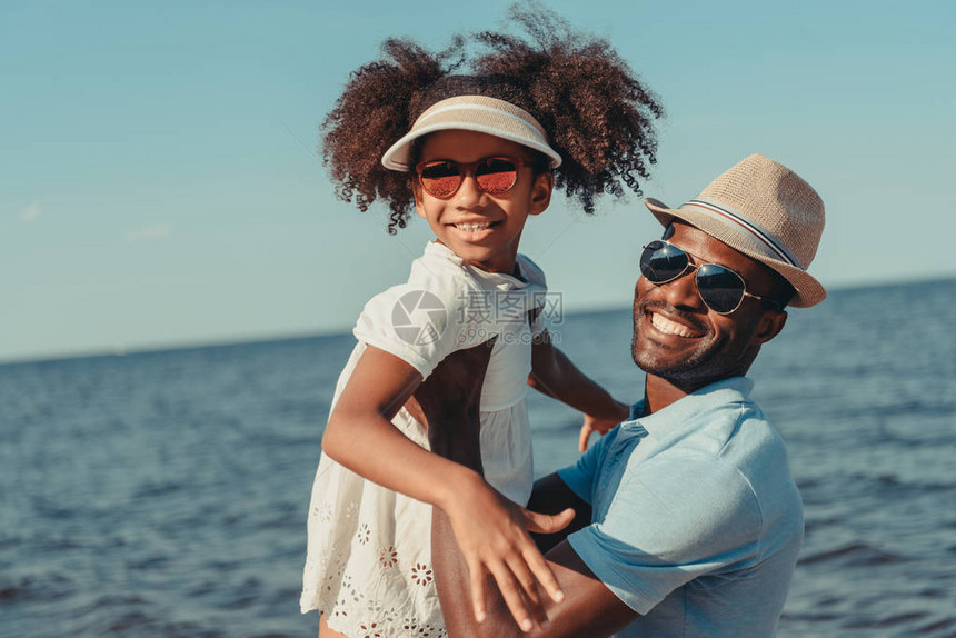 快乐的非洲美国父亲和女儿戴着墨镜看着图片